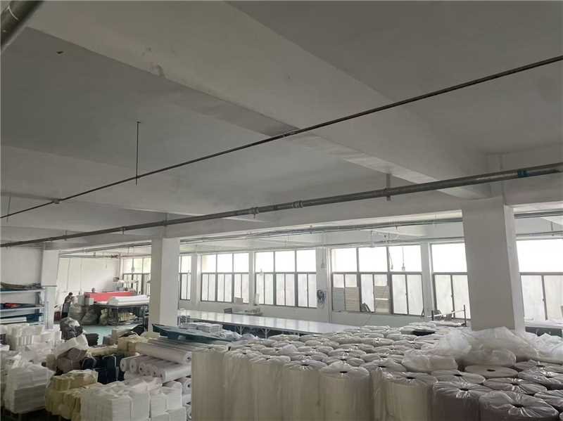 Raw materials warehouse — staged fabric rolls and hardware stock